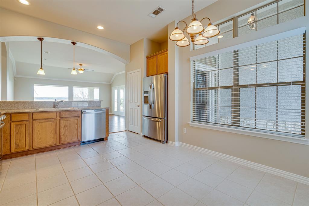 9109 Perimeter Street Denton, TX 76207 - Photo 16 of 27 Kitchen featuring light tile patterned floors, hanging light fixtures, appliances with stainless steel finishes, healthy amount of natural light, and vaulted ceiling