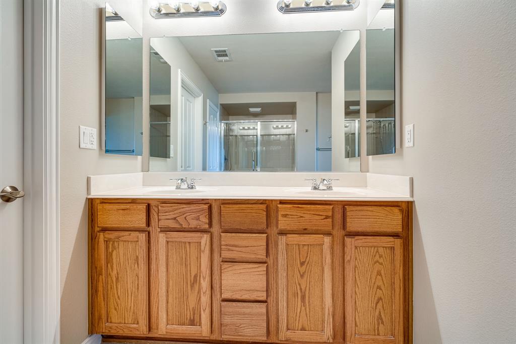 9109 Perimeter Street Denton, TX 76207 - Photo 20 of 27 Bathroom with double vanity, a shower with shower door, and a textured wall
