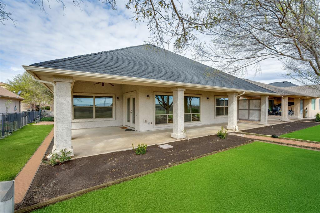9109 Perimeter Street Denton, TX 76207 - Photo 2 of 27 Back of house featuring roof with shingles, stucco siding, and a patio