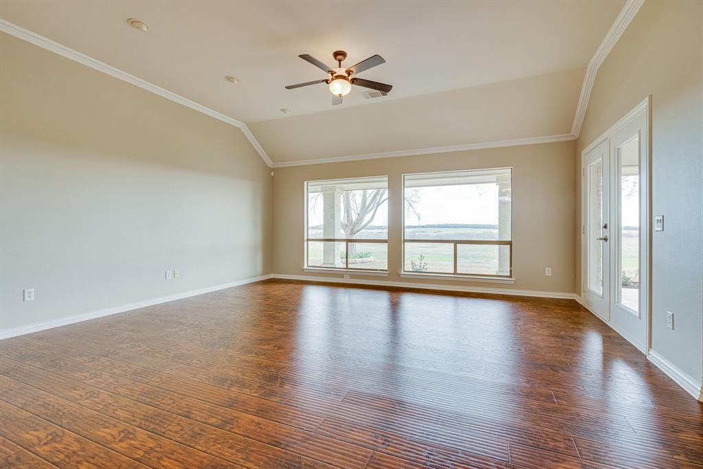 9109 Perimeter Street Denton, TX 76207 - Photo 7 of 27 Spare room featuring crown molding, plenty of natural light, dark wood finished floors, a ceiling fan, and vaulted ceiling
