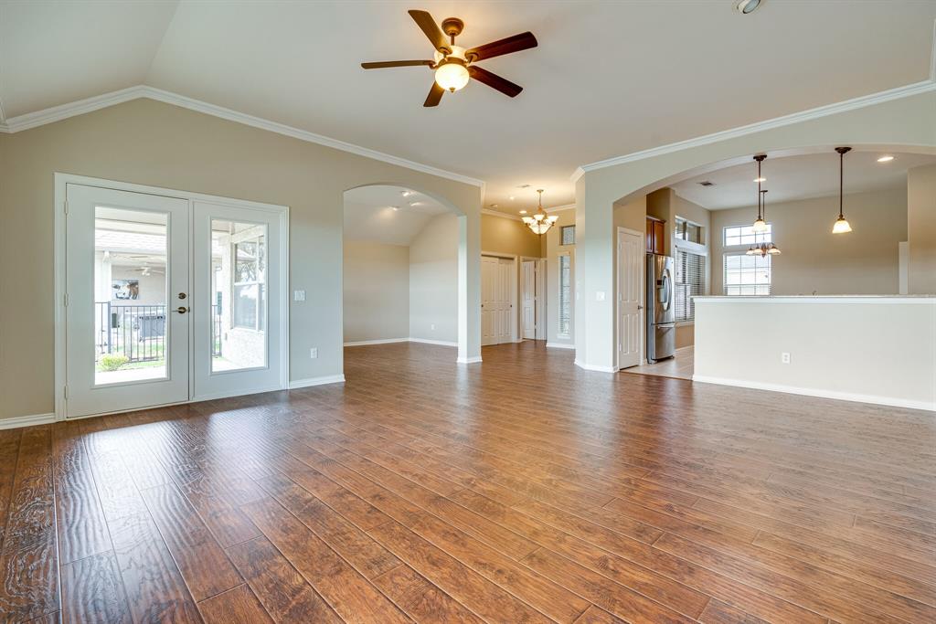 9109 Perimeter Street Denton, TX 76207 - Photo 9 of 27 Unfurnished living room with a chandelier, a ceiling fan, crown molding, french doors, and wood finished floors