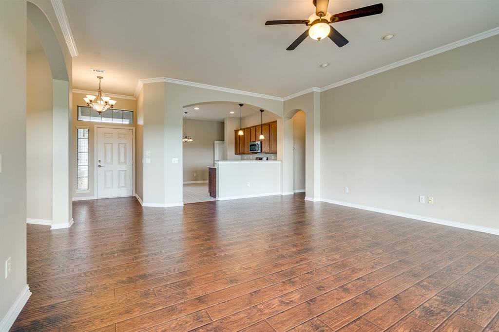 9109 Perimeter Street Denton, TX 76207 - Photo 10 of 27 Unfurnished living room featuring crown molding, arched walkways, dark wood-style flooring, a chandelier, and recessed lighting