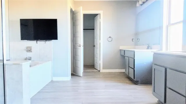 a view of a kitchen from the hallway with a bathroom