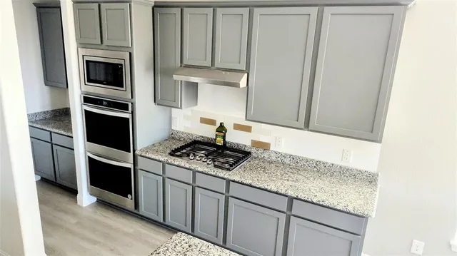a kitchen with stainless steel appliances granite countertop a stove and a microwave