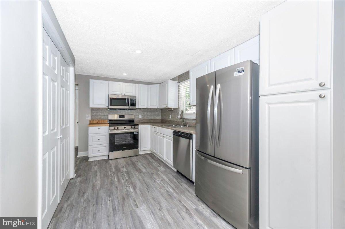 12284 Bandera Lane Lusby, MD 20657 - Photo 11 of 55 a kitchen with a refrigerator a stove top oven and kitchen island