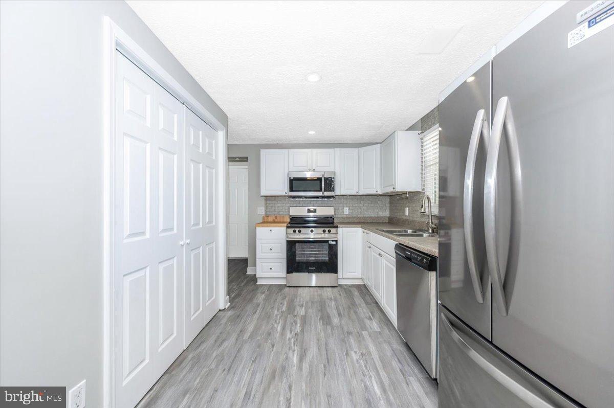 12284 Bandera Lane Lusby, MD 20657 - Photo 12 of 55 a kitchen with stainless steel appliances granite countertop a refrigerator a stove top oven a sink and dishwasher