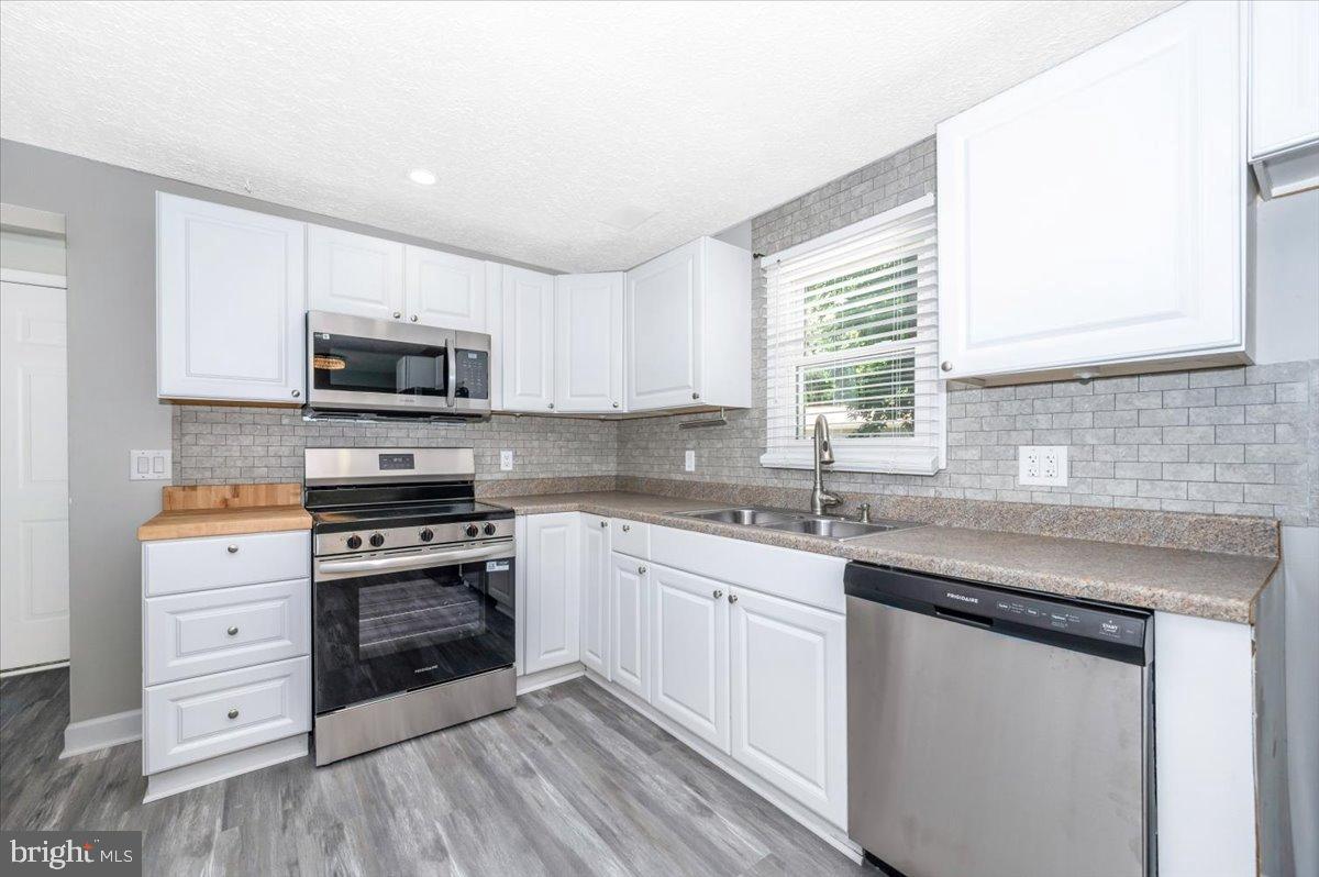 12284 Bandera Lane Lusby, MD 20657 - Photo 14 of 55 a kitchen with stainless steel appliances granite countertop a sink stove cabinets and wooden floor