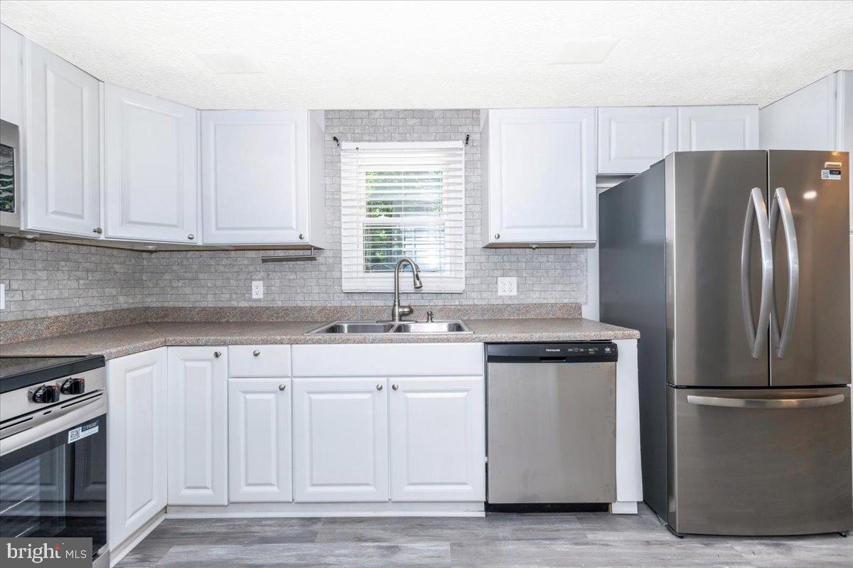 12284 Bandera Lane Lusby, MD 20657 - Photo 16 of 55 a kitchen with stainless steel appliances granite countertop a refrigerator and a sink