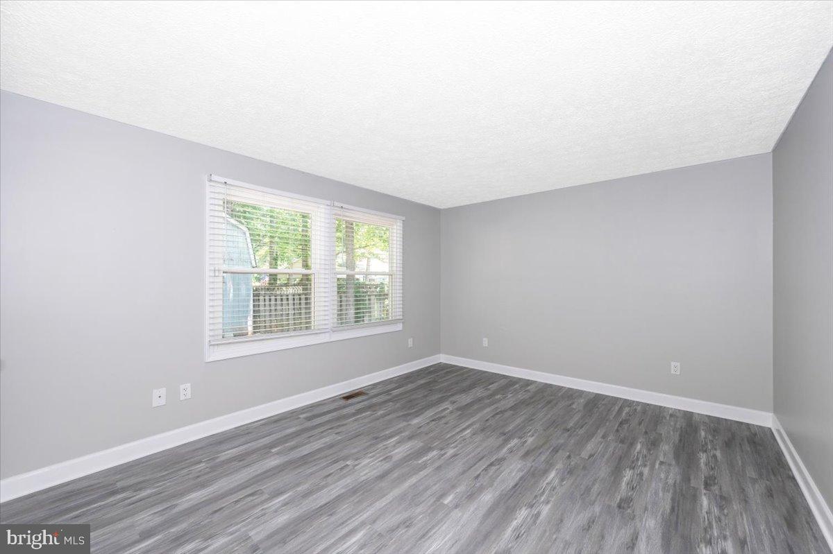 12284 Bandera Lane Lusby, MD 20657 - Photo 24 of 55 an empty room with wooden floor and windows