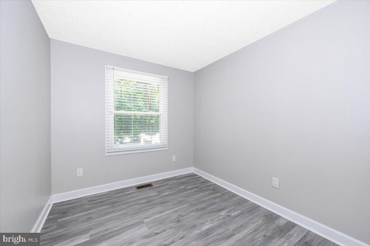 12284 Bandera Lane Lusby, MD 20657 - Photo 26 of 55 a view of an empty room with wooden floor and a window