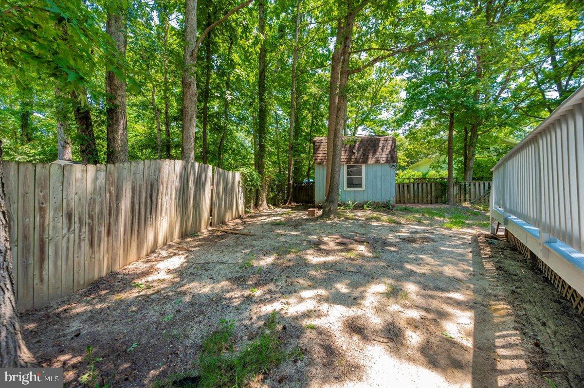 12284 Bandera Lane Lusby, MD 20657 - Photo 42 of 55 a view of a backyard with large trees and wooden fence