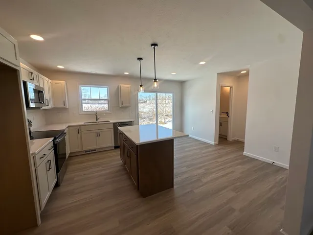 a kitchen with wooden floors and wooden cabinets