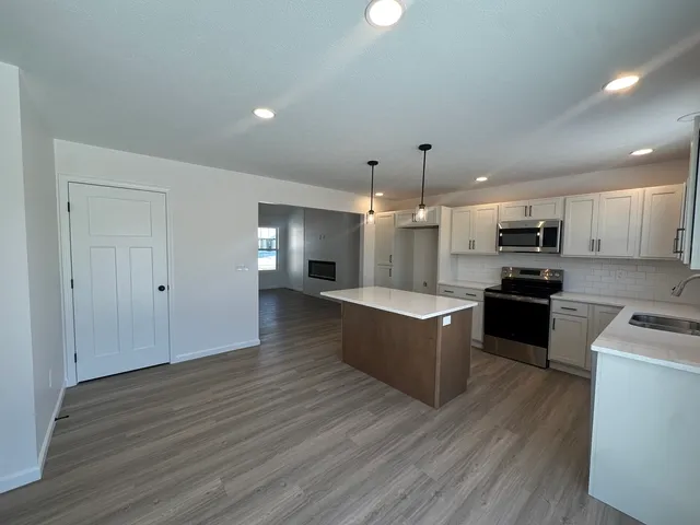a large kitchen with kitchen island a sink dishwasher stove with wooden floor