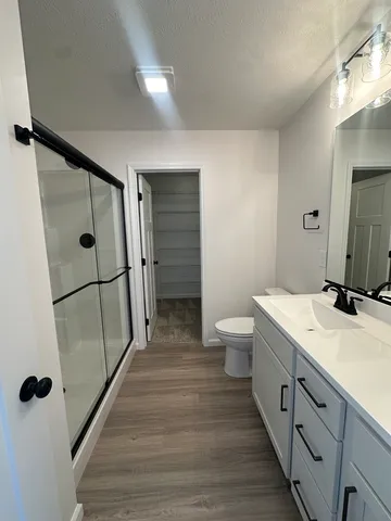 a spacious bathroom with a double vanity sink toilet and shower