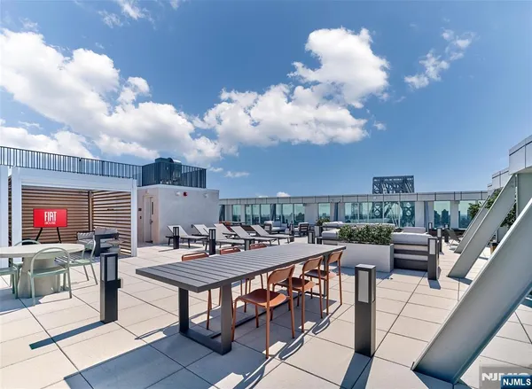 a roof deck with dining table and chairs