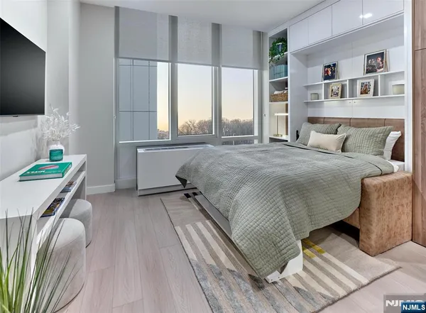 a spacious bedroom with a bed and a flat screen tv