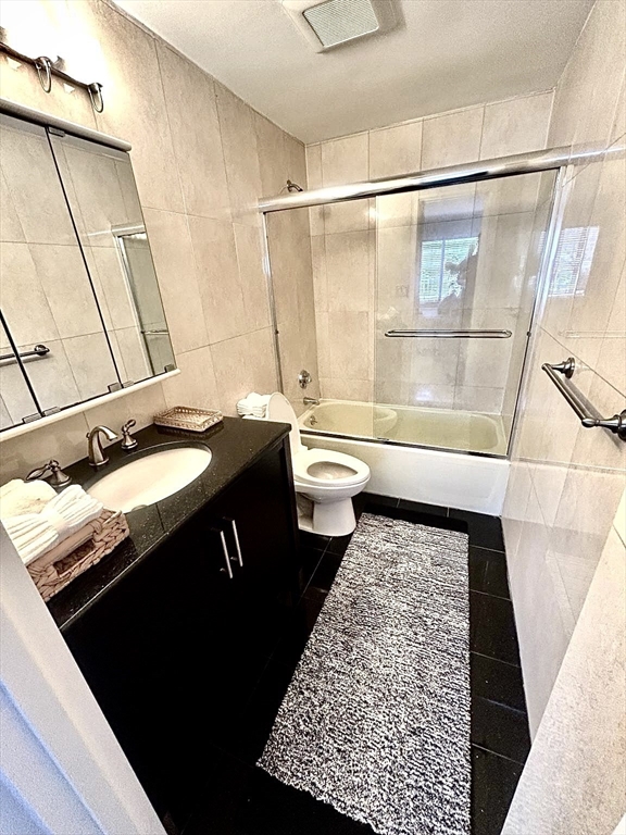 22 Chestnut Place, Unit 210 Brookline, MA 02445 - Photo 6 of 16 a bathroom with a granite countertop sink toilet and shower