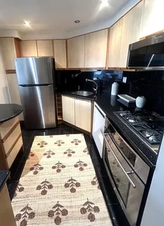 a kitchen with a refrigerator and a stove top oven