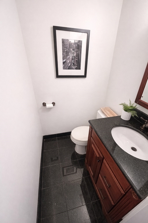 22 Chestnut Place, Unit 210 Brookline, MA 02445 - Photo 9 of 16 a bathroom with a toilet a sink and mirror