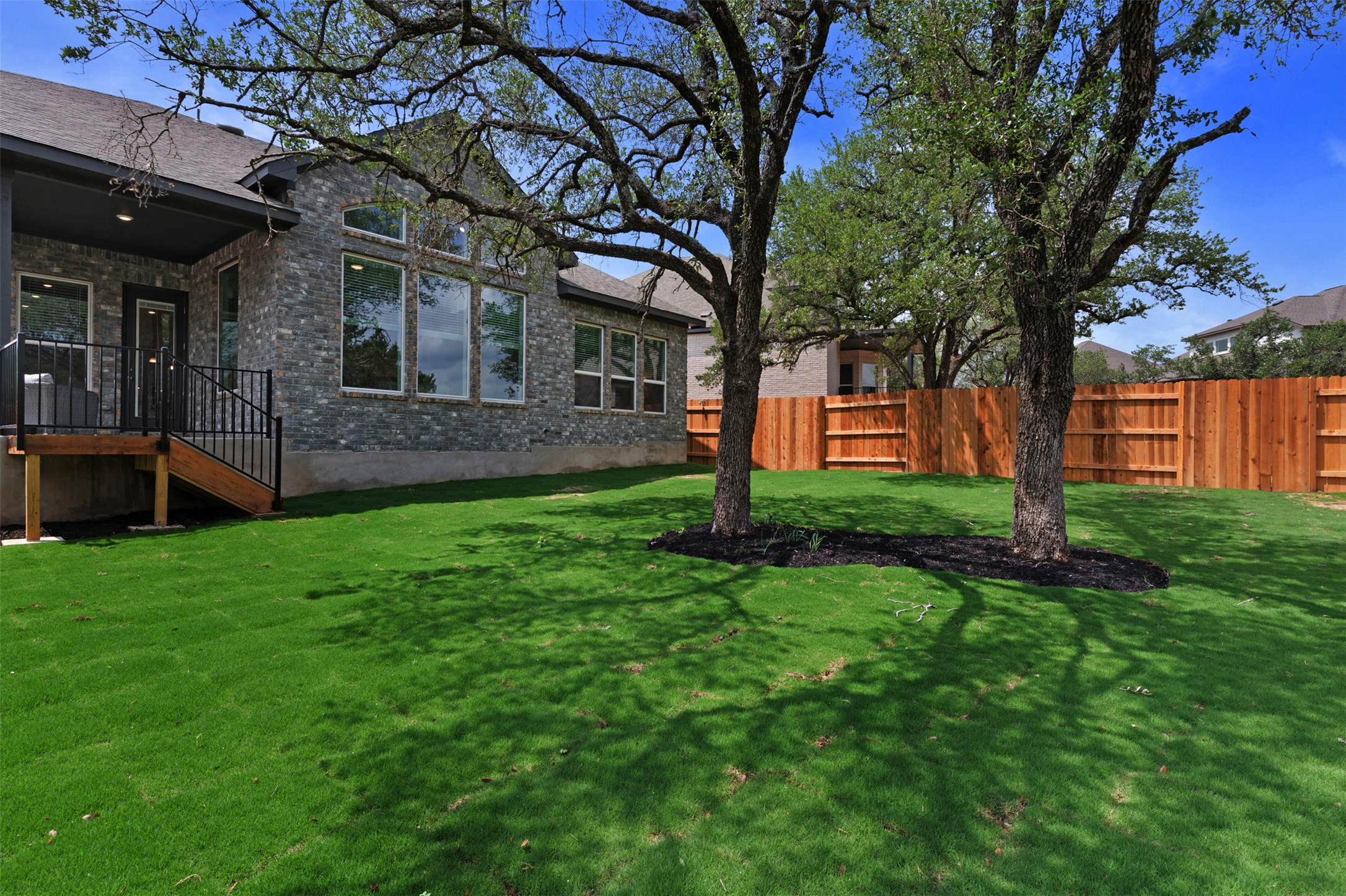 104 Beautiful Wisdom Court Georgetown, TX 78628 - Photo 25 of 33 a view of a yard in front of a brick house with a large tree