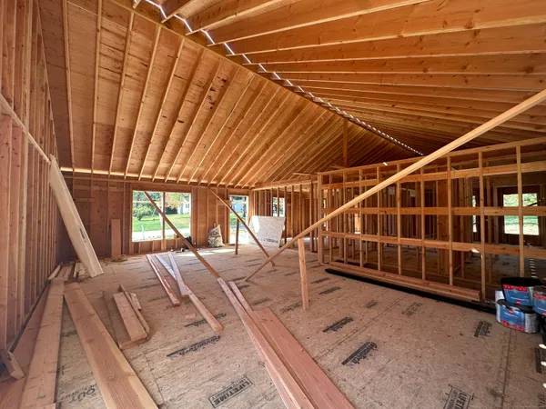 a view of an empty room with wooden floor and windows