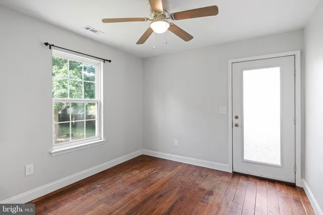 wooden floor in an empty room with a window