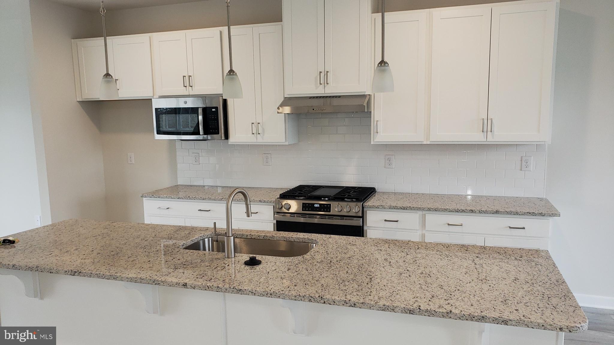 214 Case Road Townsend, DE 19734 - Photo 5 of 18 a kitchen with granite countertop a sink a stove and cabinets
