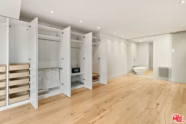 a large bedroom with a large bed and wooden floor