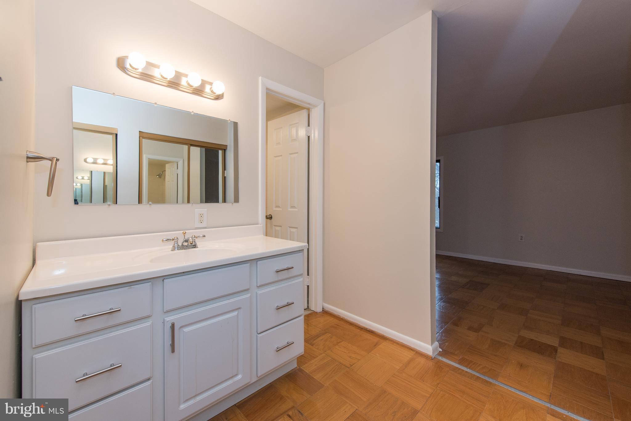 5232 West Running Brook Road, Unit 301 Columbia, MD 21044 - Photo 25 of 29 a bathroom with a double vanity sink and mirror