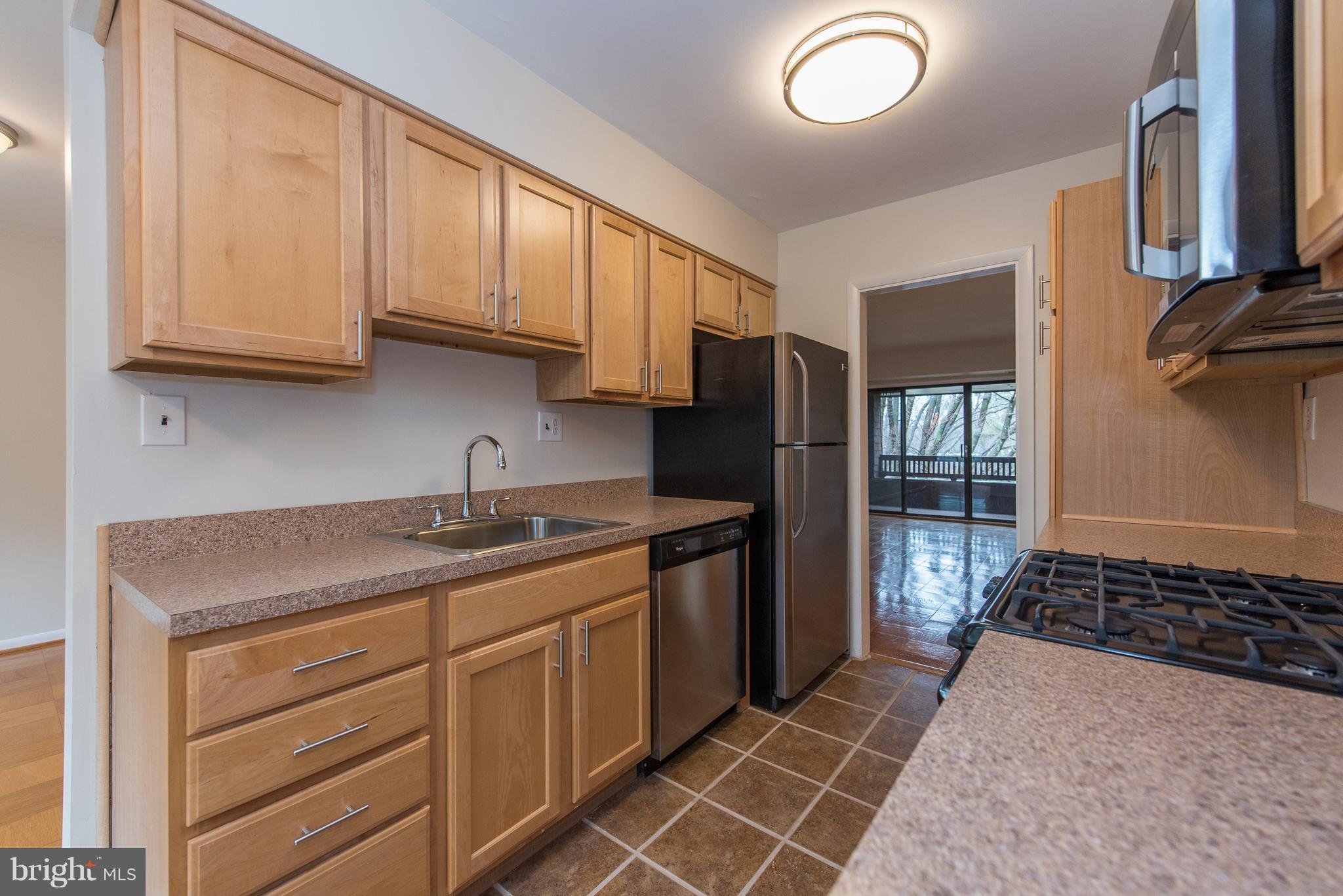 5232 West Running Brook Road, Unit 301 Columbia, MD 21044 - Photo 8 of 29 a kitchen with stainless steel appliances granite countertop a sink stove and refrigerator