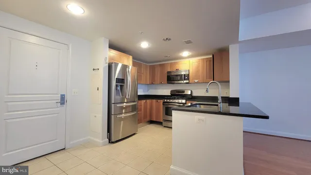 a kitchen with stainless steel appliances granite countertop a refrigerator and a stove top oven