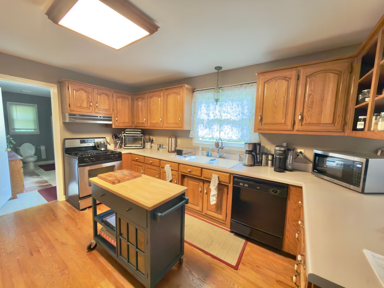 3080 Pleasant Ridge Road Woodbury, TN 37190 - Photo 8 of 19 a kitchen with stainless steel appliances granite countertop a stove a sink dishwasher and a microwave oven with white cabinets