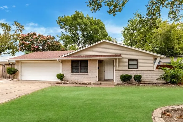 a view of a white house with a yard and potted plants