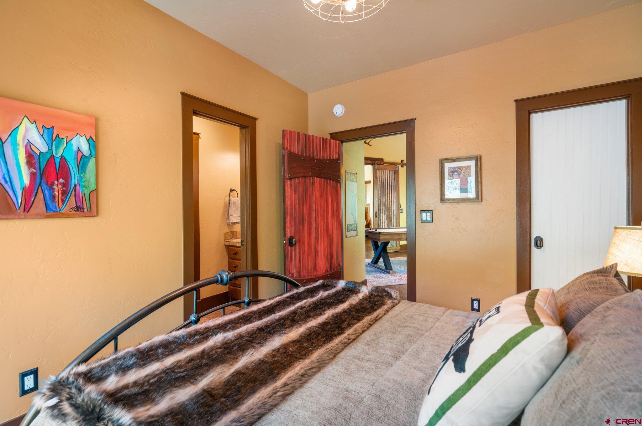 145 Ute Pass W Road Durango, CO 81301 - Photo 21 of 35 a bedroom with a bed a painting on the wall and a potted plant