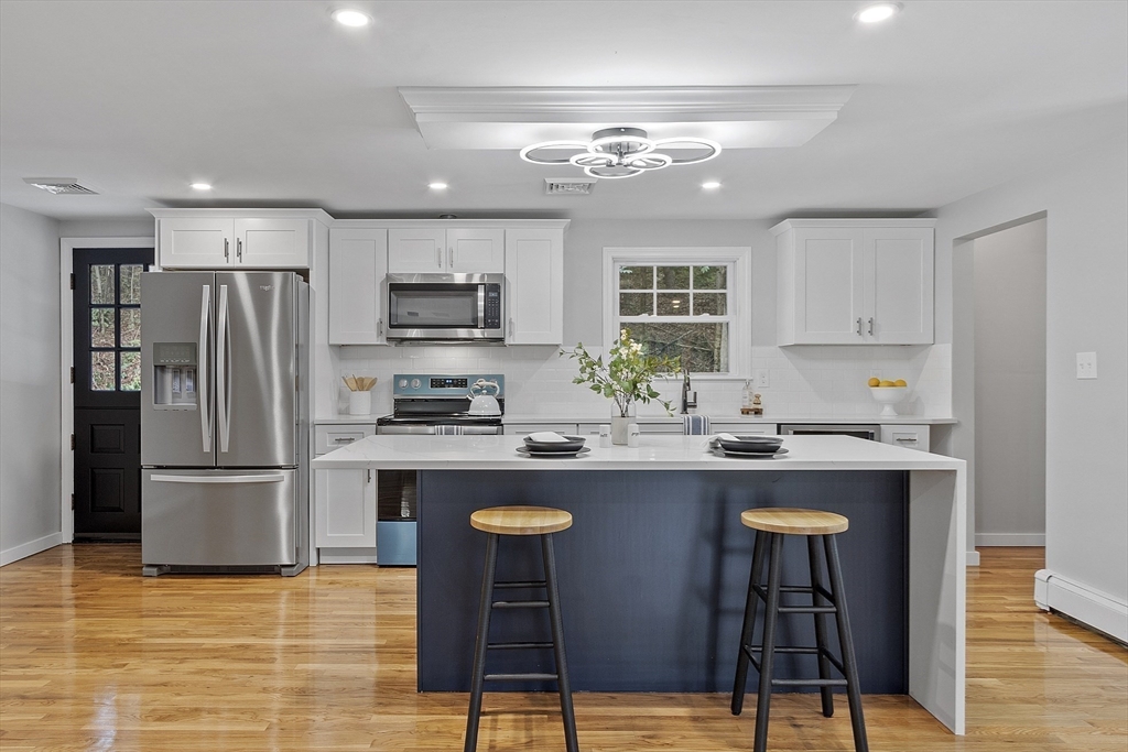 167 Harvard Road Stow, MA 01775 - Photo 11 of 27 a kitchen with kitchen island granite countertop a sink stove and refrigerator