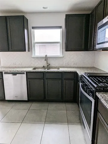 a kitchen with a sink stove top oven and cabinets