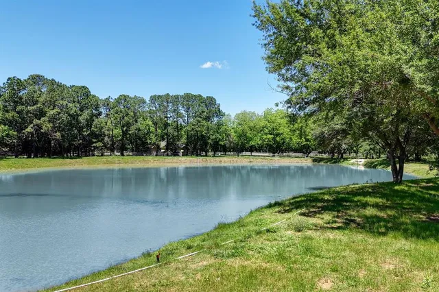 a view of a lake with a yard and trees