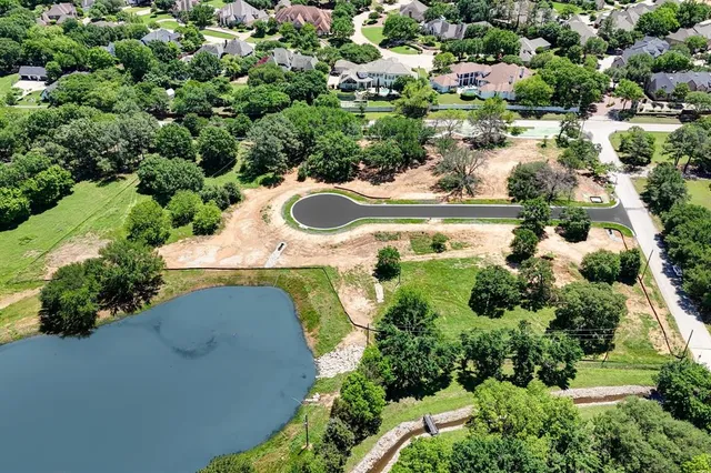 an aerial view of a house with a yard and lake view