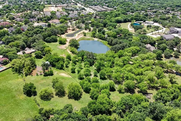 an aerial view of residential house with outdoor space and trees all around