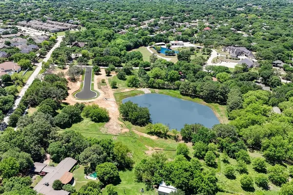 an aerial view of residential house with outdoor space and trees all around