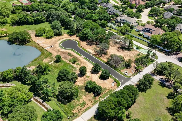 an aerial view of residential house with outdoor space and trees all around