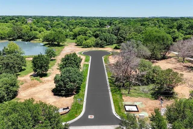 an aerial view of a house with a yard and lake view