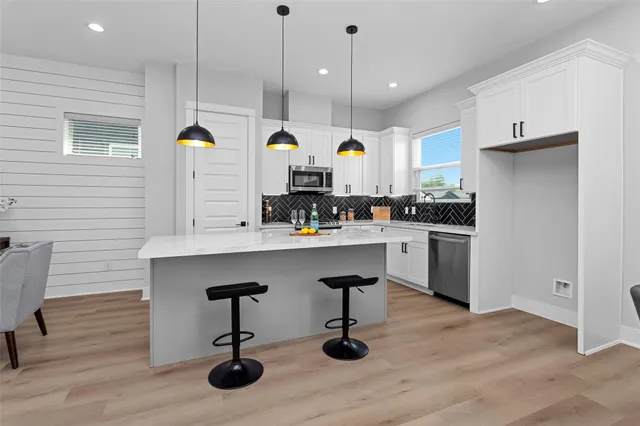 a kitchen with kitchen island stainless steel appliances a dining table and chairs