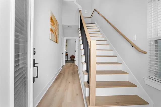 a view of a hallway with wooden floor and entryway
