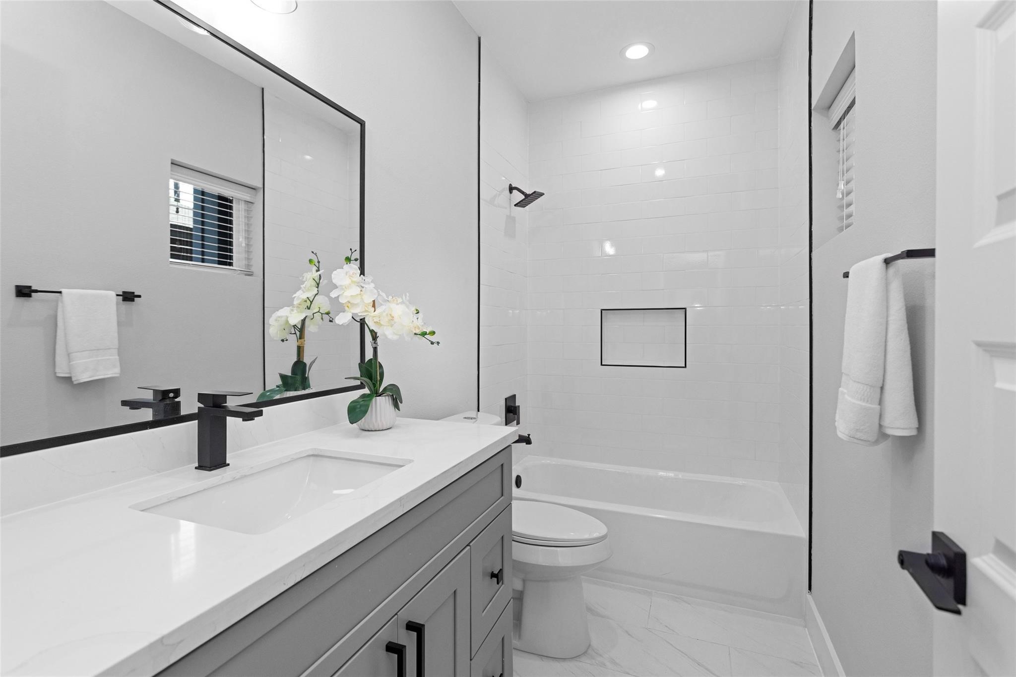 1616 Euel Street Houston, TX 77009 - Photo 10 of 42 a bathroom with a granite countertop sink a toilet and shower