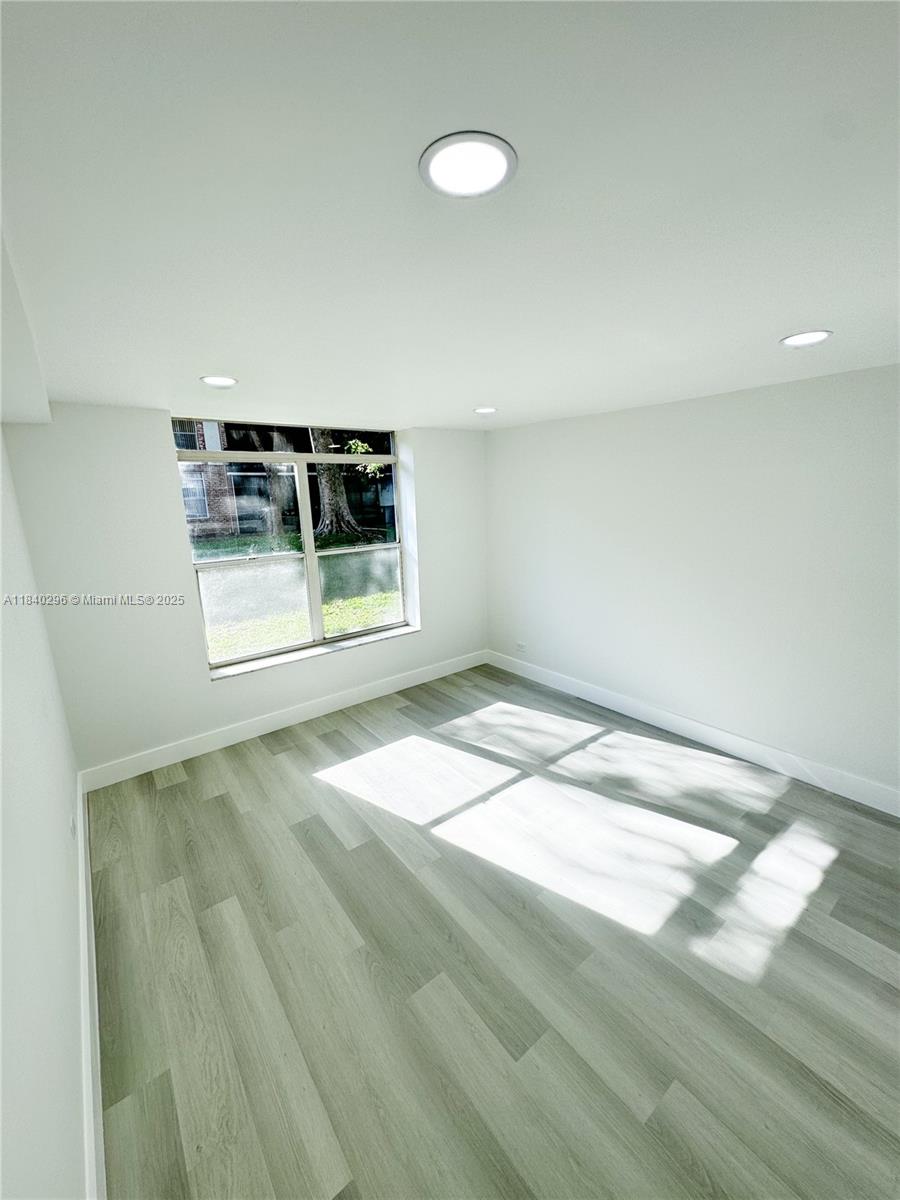 3660 Inverrary Drive, Unit 1Y Lauderhill, FL 33319 - Photo 18 of 24 a view of a room with a wooden floor and white walls