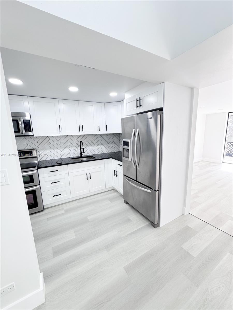 3660 Inverrary Drive, Unit 1Y Lauderhill, FL 33319 - Photo 4 of 24 a kitchen with granite countertop stainless steel appliances and white cabinets