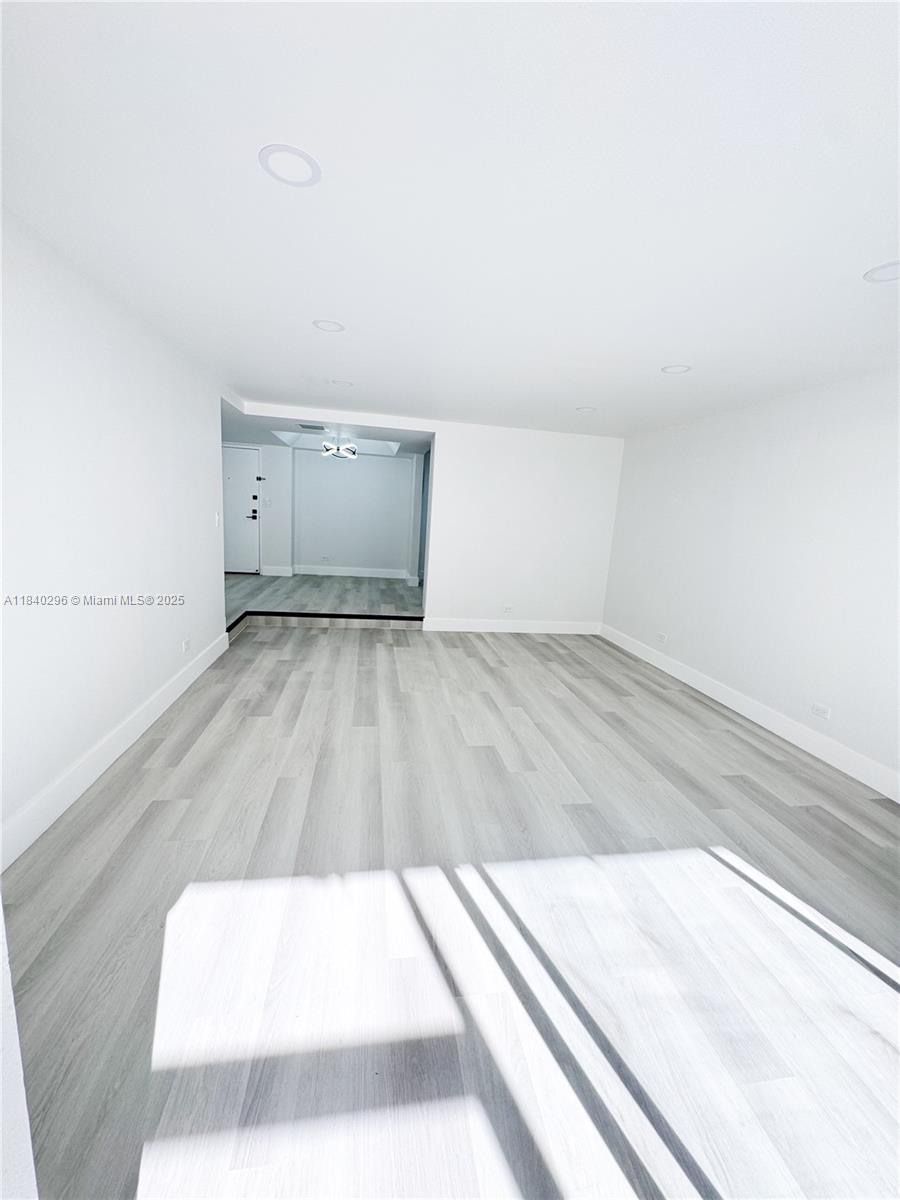 3660 Inverrary Drive, Unit 1Y Lauderhill, FL 33319 - Photo 5 of 24 an empty room with wooden floor and windows