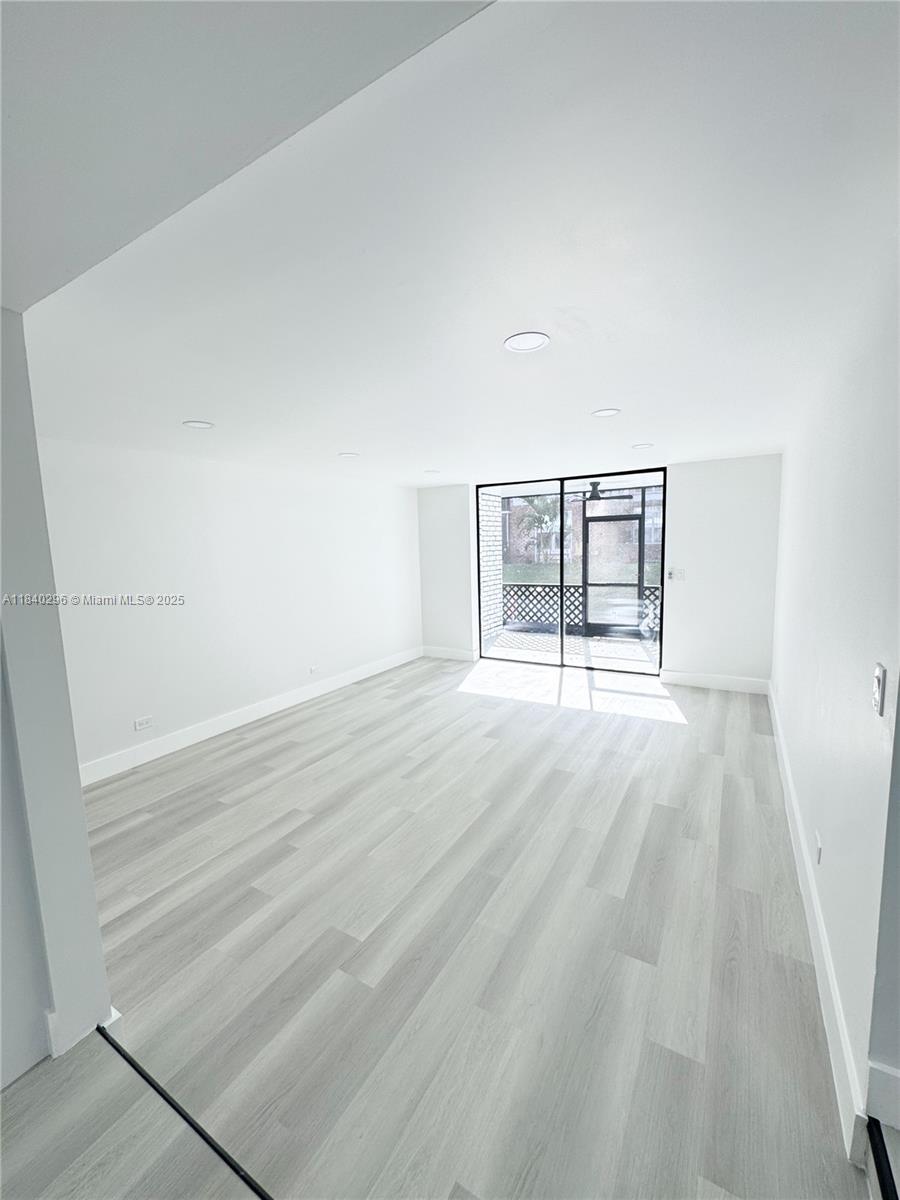 3660 Inverrary Drive, Unit 1Y Lauderhill, FL 33319 - Photo 6 of 24 wooden floor in an empty room with a window