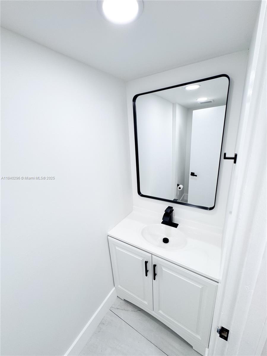 3660 Inverrary Drive, Unit 1Y Lauderhill, FL 33319 - Photo 8 of 24 a white bathroom with mirror and window